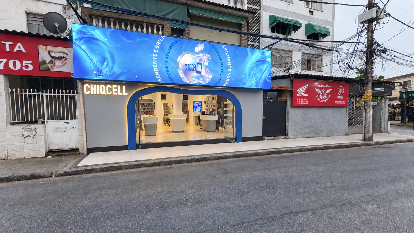 Fachada da Chiq Cell no Ponto Chic, com o letreiro iluminado, painel azul e entrada em arco.